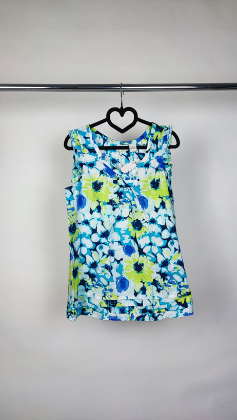 تصویر نیمقد زنی با تاپ بدونآستین طرحدار آبی‑سبز با زمینه روشن، در پسزمینه سفید.»