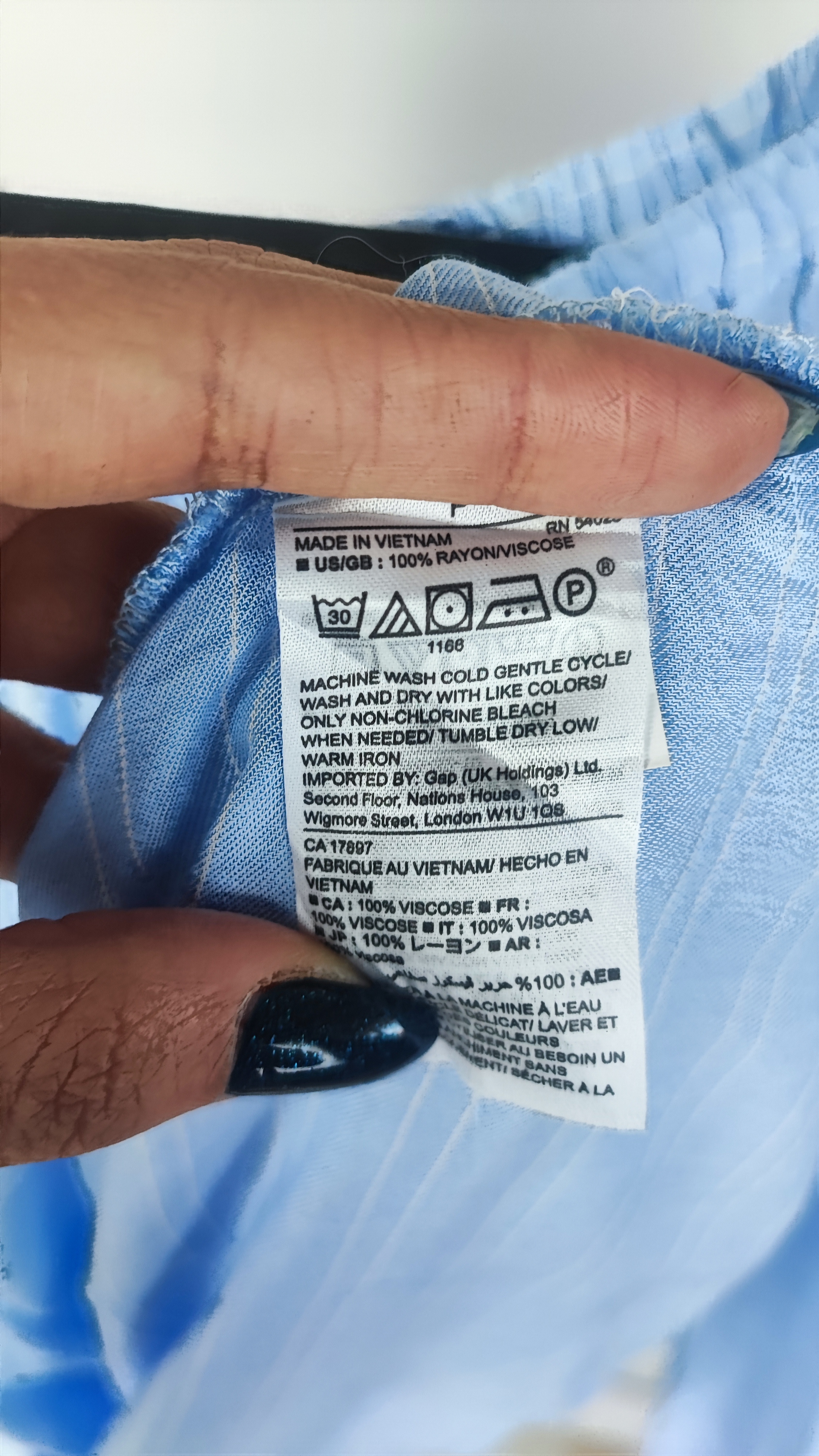 تصویر نیم‌تنه زنی که شومیز آبی روشن یقه‌کش و شانه‌باز با آستین بلند پوشیده استصویر نیم‌تنه زنی که شومیز آبی روشن یقه‌کش و شانه‌باز با آستین بلند پوشیده است. فرم لباس آزاد است و پس‌زمینه روشن و ساده است.»ت. فرم لباس آزاد است و پس‌زمینه روشن و ساده است.»