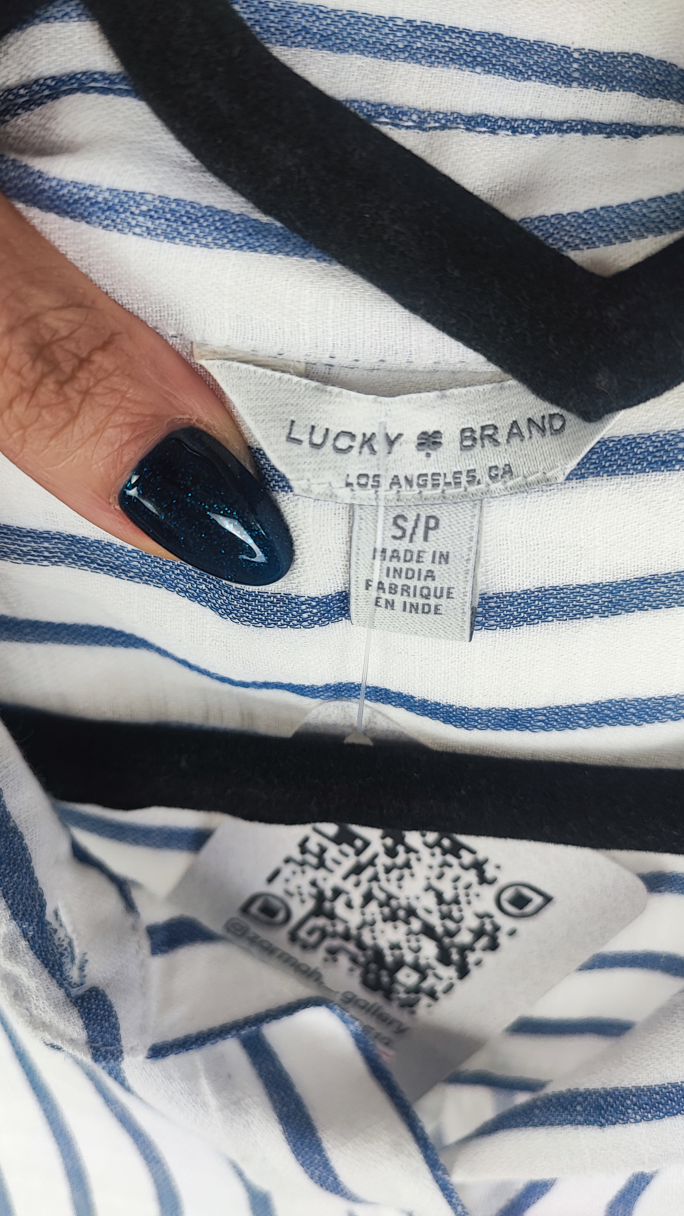 تصویر نیم‌تنه زنی با شومیز آستین‌بلند راه‌راه عمودی آبی و سفید، با یقه‌دار و فرم نیمه‌راسته. پس‌زمینه روشن و ساده است.»