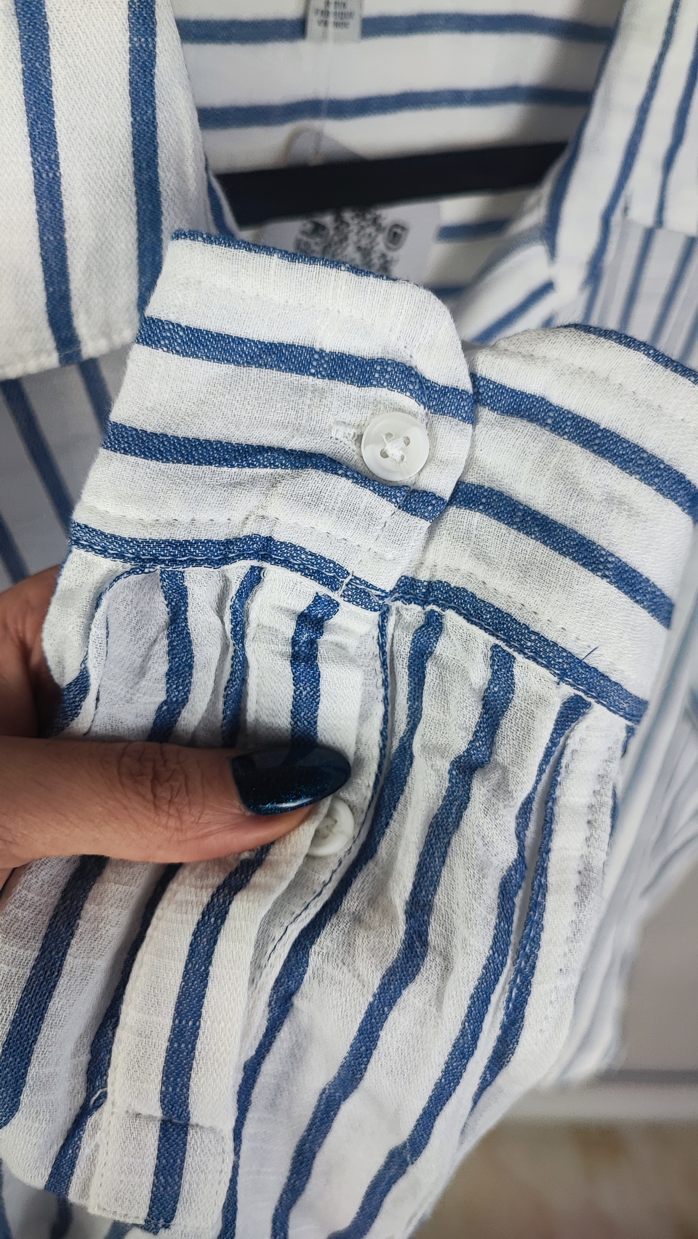 تصویر نیم‌تنه زنی با شومیز آستین‌بلند راه‌راه عمودی آبی و سفید، با یقه‌دار و فرم نیمه‌راسته. پس‌زمینه روشن و ساده است.»