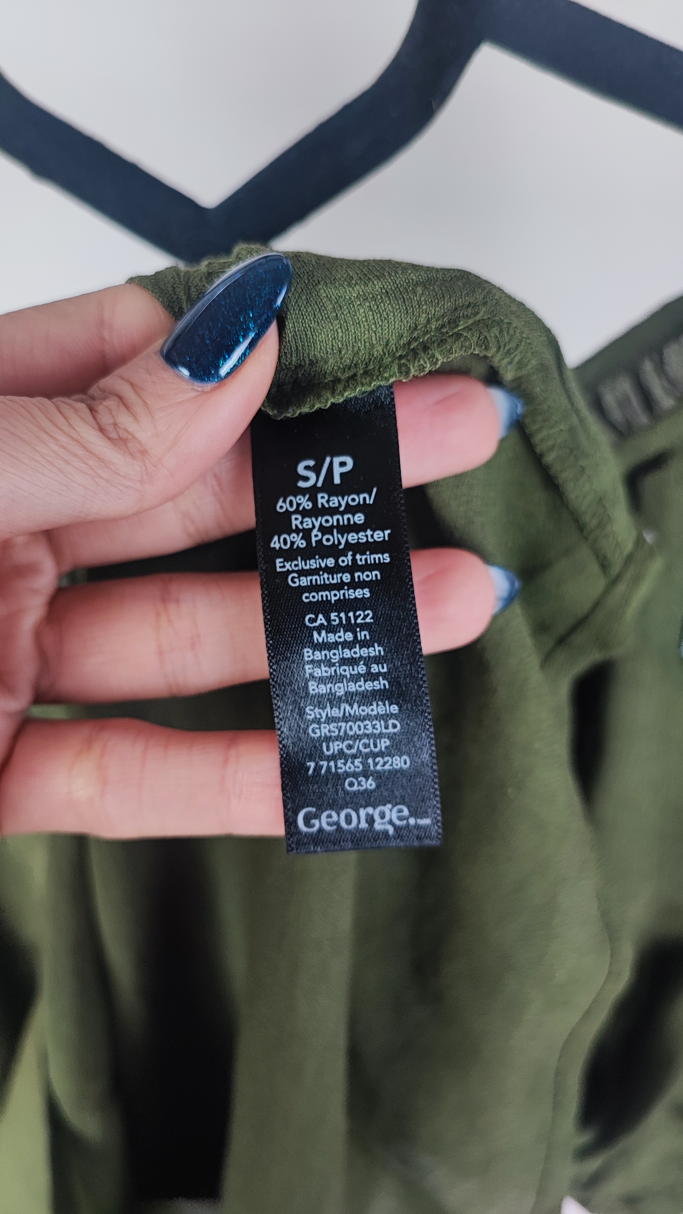 تصویر تمام‌قد زنی با شومیز سبز تیره آستین‌کوتاه و فرم آزاد که با شلوار جین تیره ست شده است. یقه گرد و پارچه سبک دارد