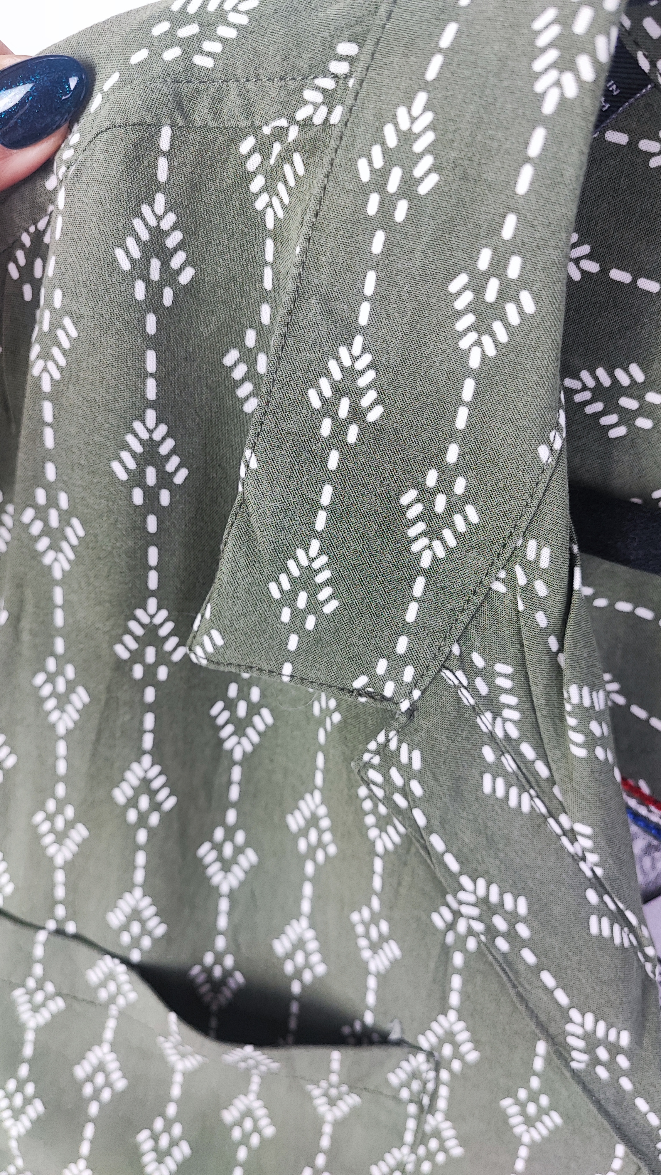 تصویر تمام‌قد زنی با شومیز سبز یشمی با یقه هفت و آستین کوتاه، ست‌شده با شلوار جین تیره. پس‌زمینه سفید و ساده است.»