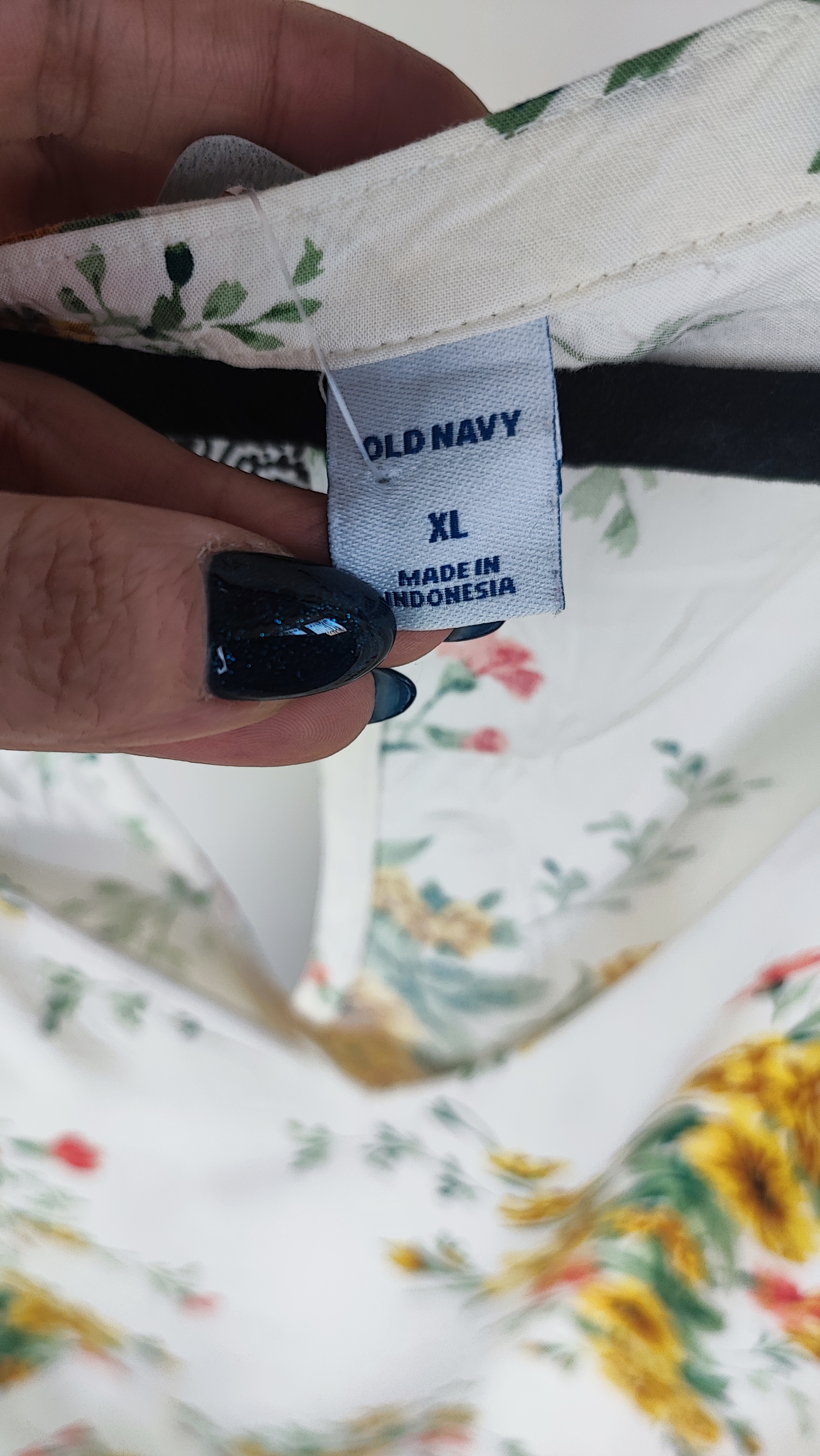 تصویر تمام‌قد زنی با تاپ بدون‌آستین روشنِ طرح‌دار با یقه هفت، ست‌شده با شلوار جین تیره. پس‌زمینه سفید و ساده است