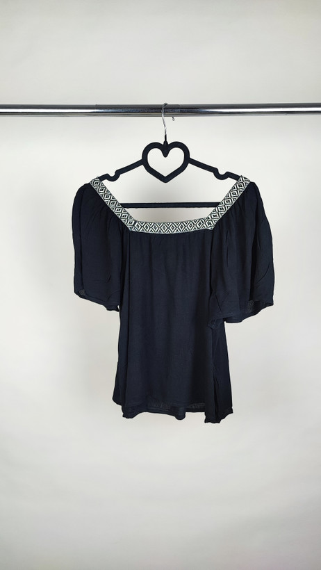 تصویر نیمقد زنی با شومیز مشکی مجلسی یقهلمهدار و آستین کوتاه فون، در پسزمینه سفید