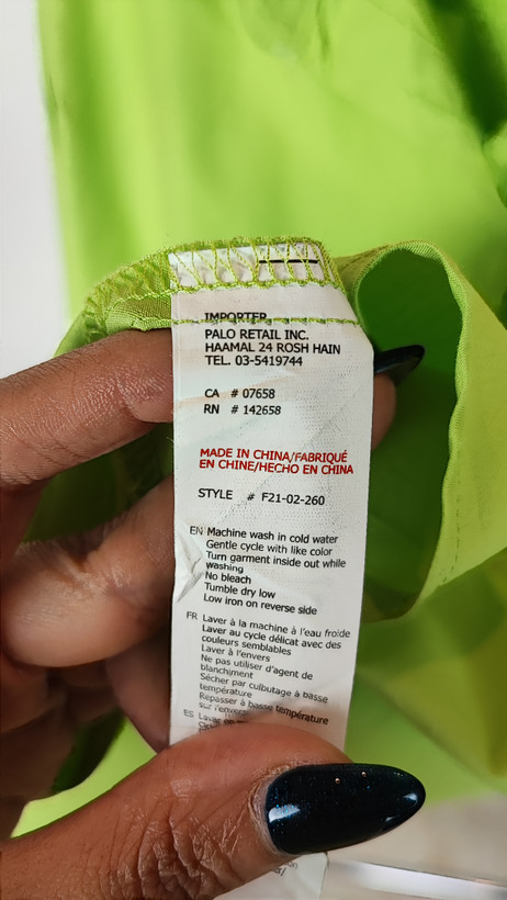 زن با شومیز لیمویی روشن آستینبلند و یقه برگردان دیده میشود. فرم لباس آزاد است و با شلوار جین تیره ست شده.»