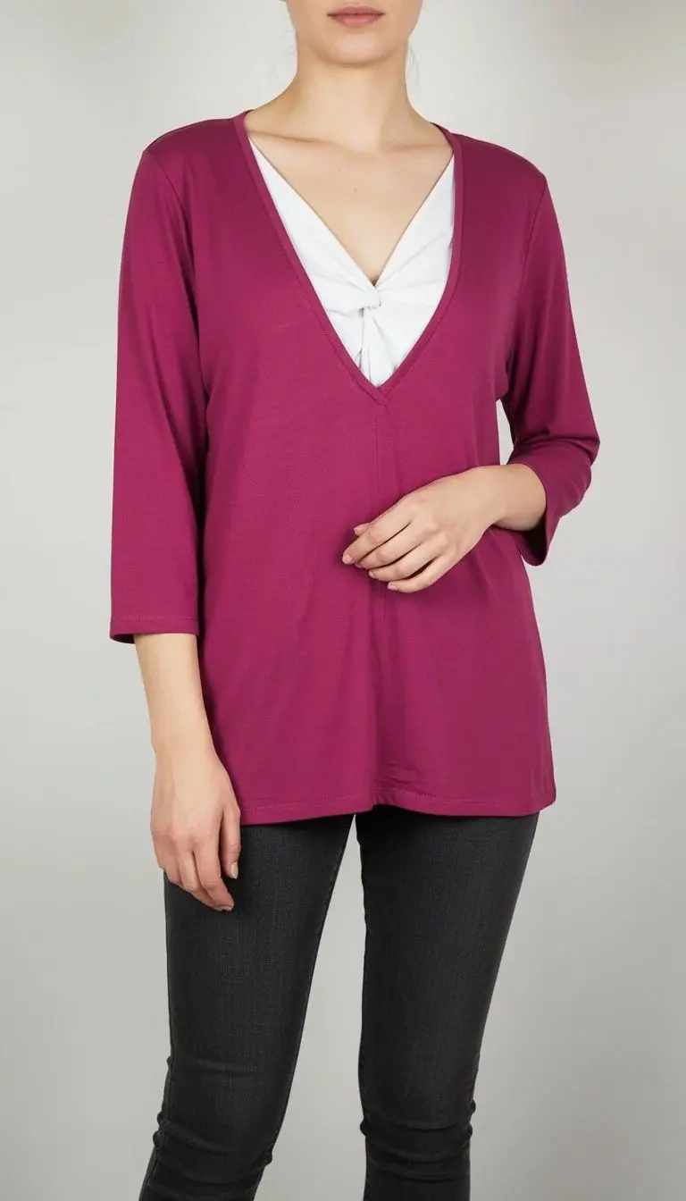 زن با بلوز زنانه صورتی تیره یقه‌هفت عمیق و آستین سه‌ربع، همراه با تاپ سفید زیر آن، در پس‌زمینه روشن ایستاده است.»