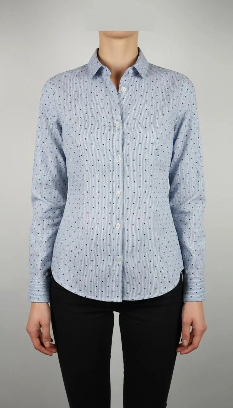 زن با شومیز آبیروشن دکمهدار و یقهبرگردان، آستینبلند و بدون طرح، در پسزمینه روشن ایستاده است