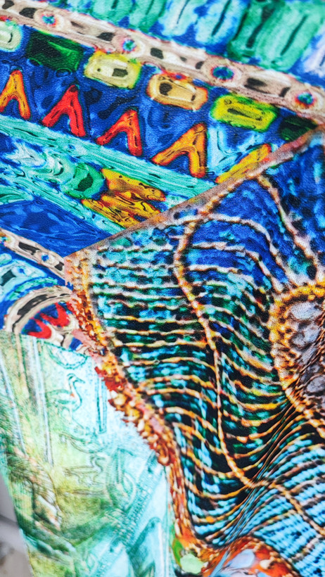 زن با پیراهن کوتاه طرحدار چندرنگ با آستین کوتاه و قد تا بالای زانو در پسزمینه روشن ایستاده است.»