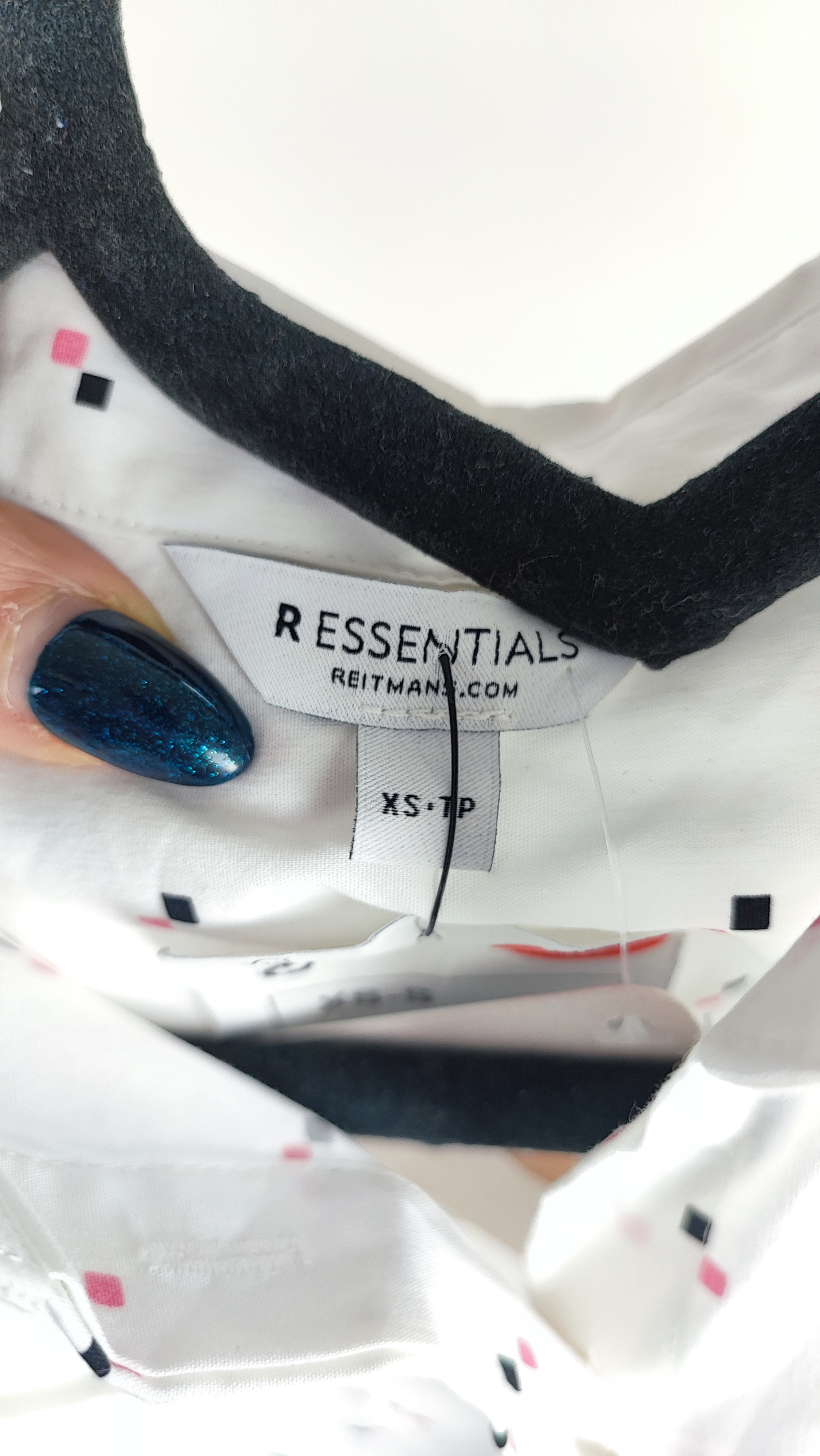 زن ایستاده با شومیز سفید آستین‌کوتاه و یقه‌دار، همراه با شلوار جین روشن در پس‌زمینه ساده.»