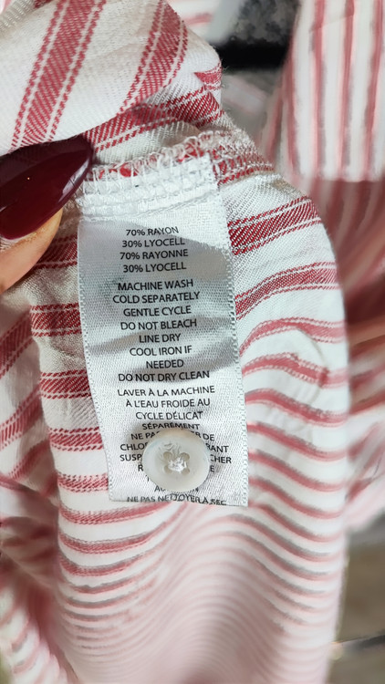 زن سایزبزرگ با شومیز راهراه روشن آستینکوتاه و یقهدار در پسزمینه ساده.»