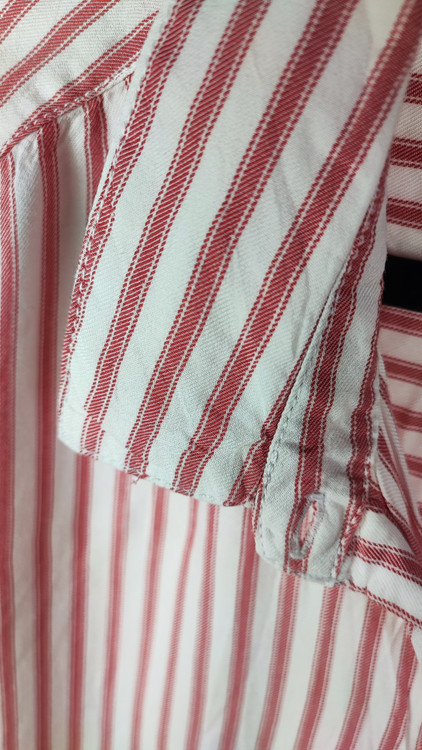 زن سایزبزرگ با شومیز راهراه روشن آستینکوتاه و یقهدار در پسزمینه ساده.»