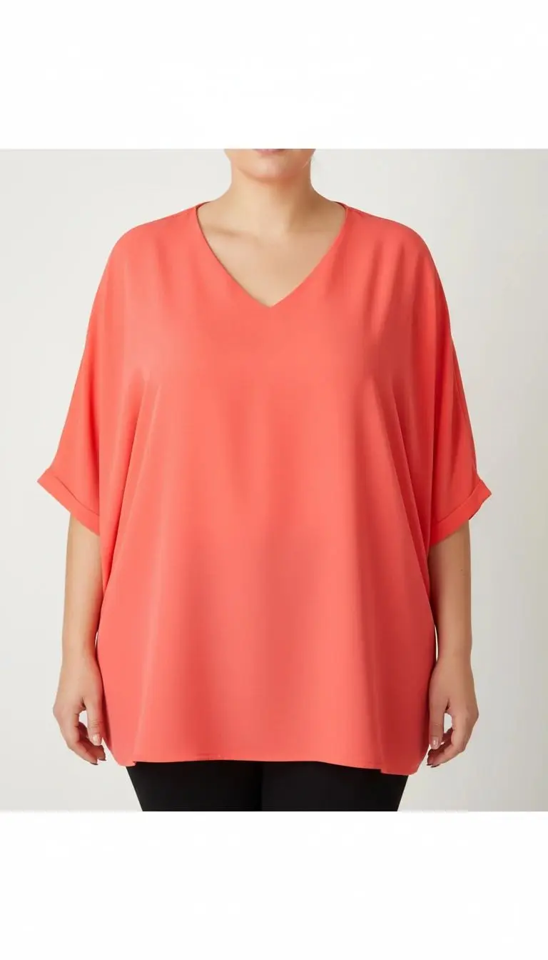 زن سایزبزرگ با شومیز آزاد یقه‌هفت کوتاه‌آستین به رنگ گلبهی در پس‌زمینه ساده.»