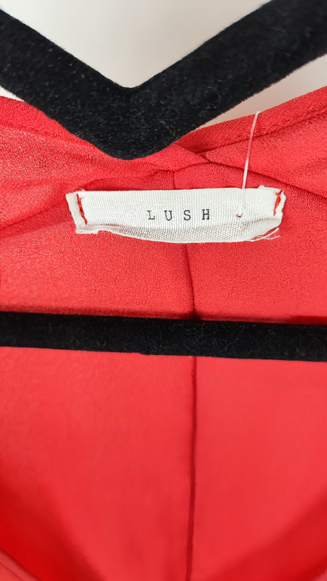 زن سایزبزرگ با شومیز آزاد یقههفت کوتاهآستین به رنگ گلبهی در پسزمینه ساده.»