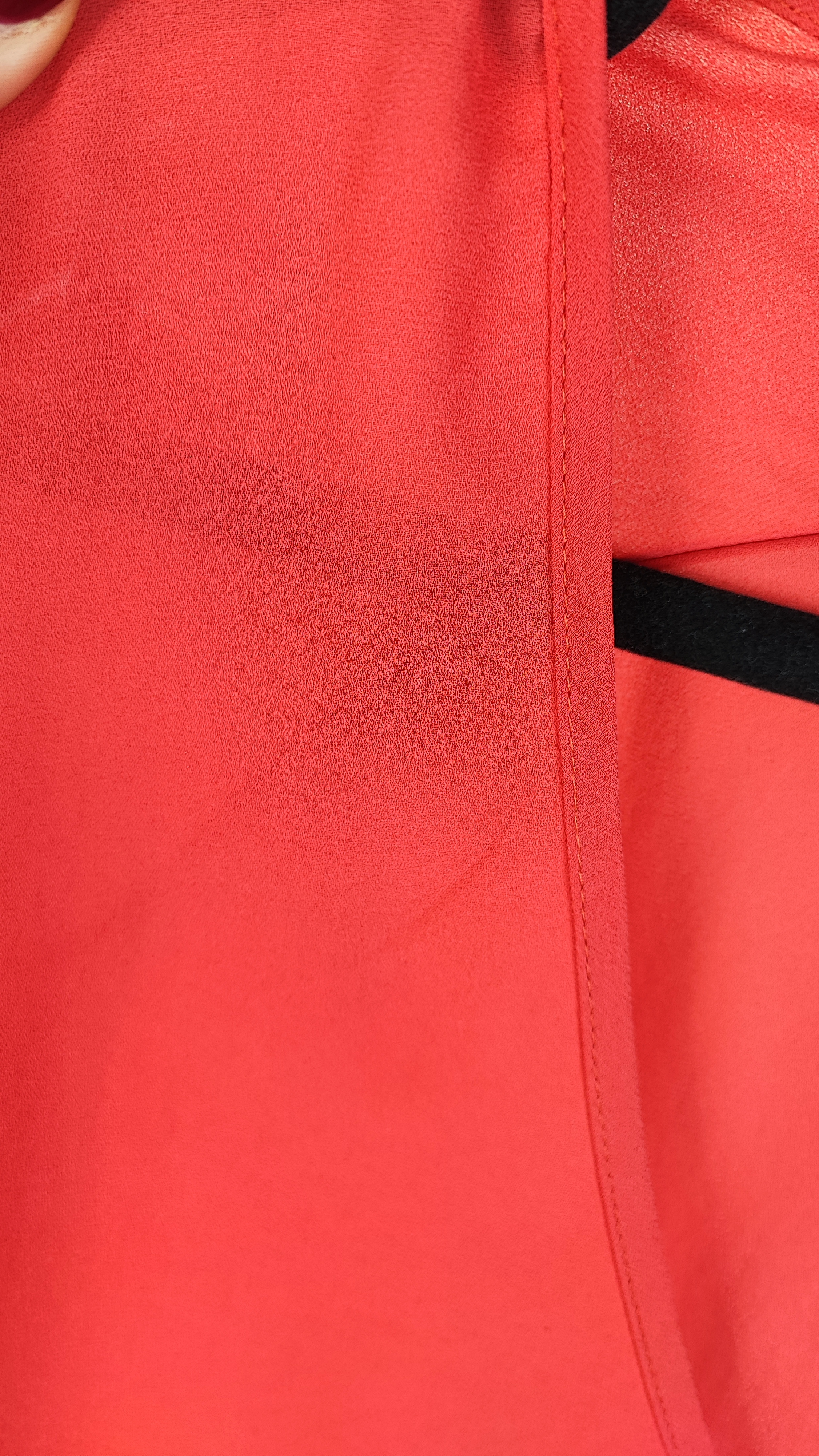 زن سایزبزرگ با شومیز آزاد یقه‌هفت کوتاه‌آستین به رنگ گلبهی در پس‌زمینه ساده.»