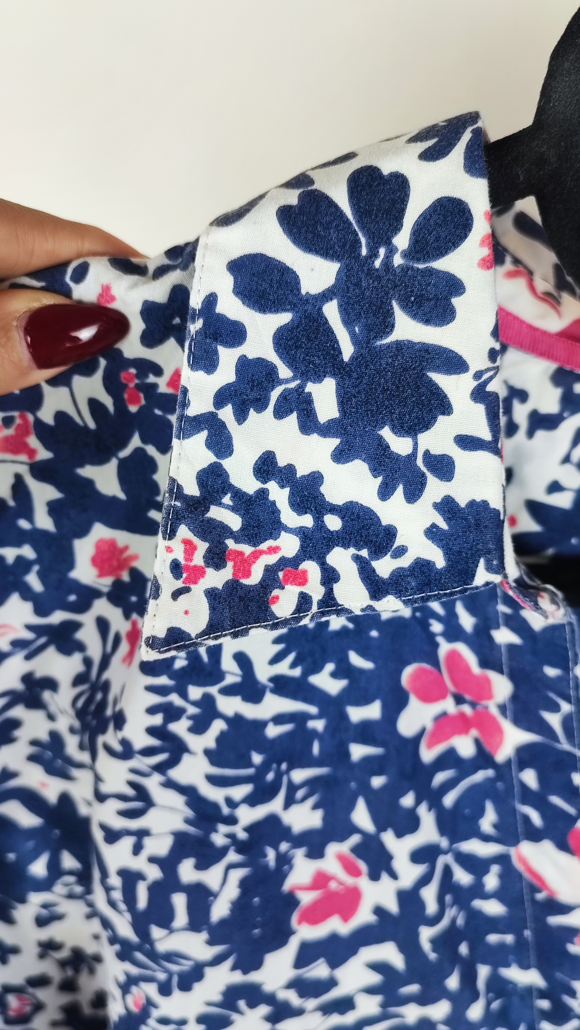 زن سایزبزرگ با تاپ بدون‌آستین آبی طرح‌دار و شلوار جین در پس‌زمینه ساده.»