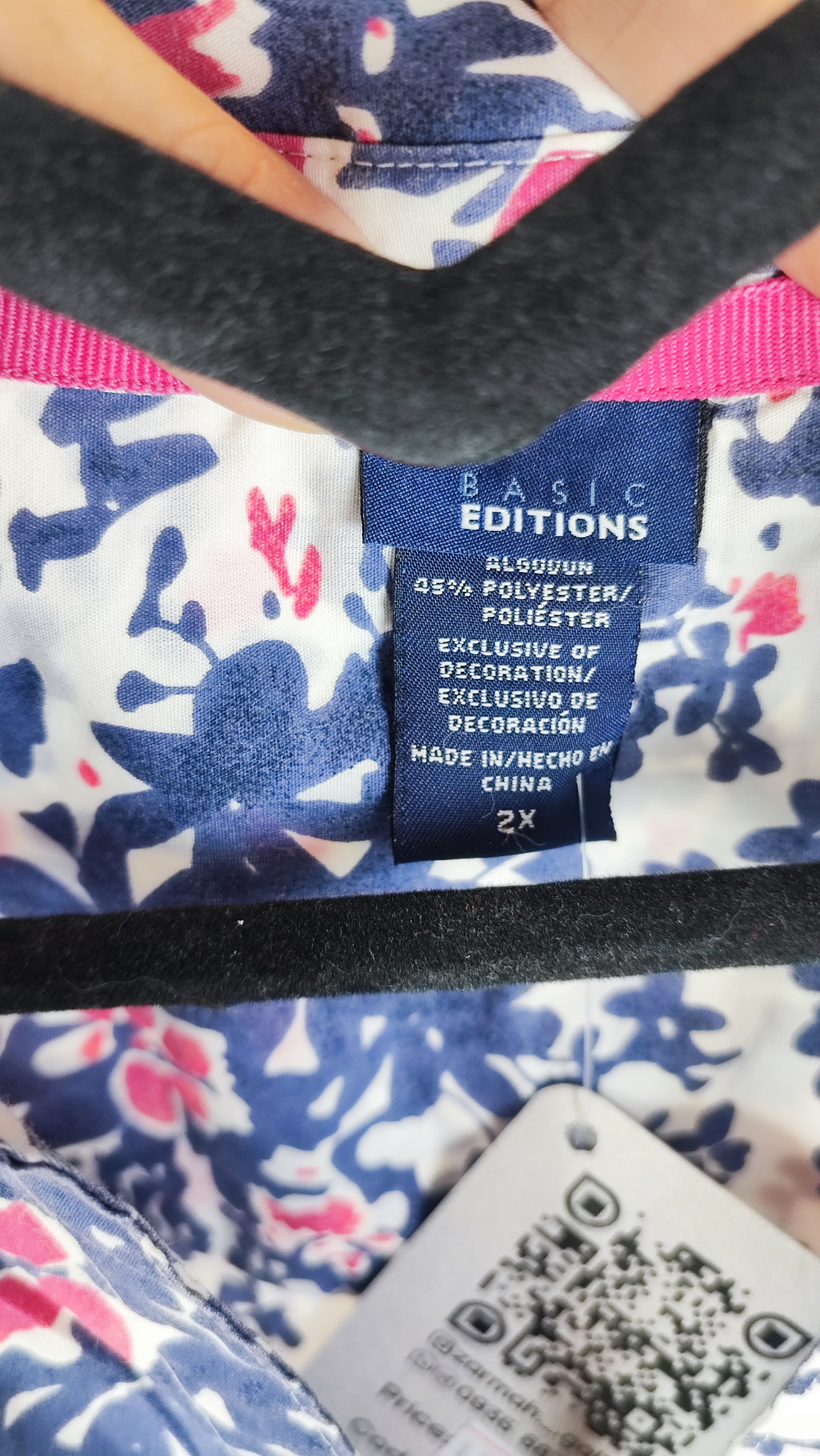 زن سایزبزرگ با تاپ بدون‌آستین آبی طرح‌دار و شلوار جین در پس‌زمینه ساده.»