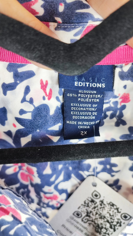 زن سایزبزرگ با تاپ بدونآستین آبی طرحدار و شلوار جین در پسزمینه ساده.»