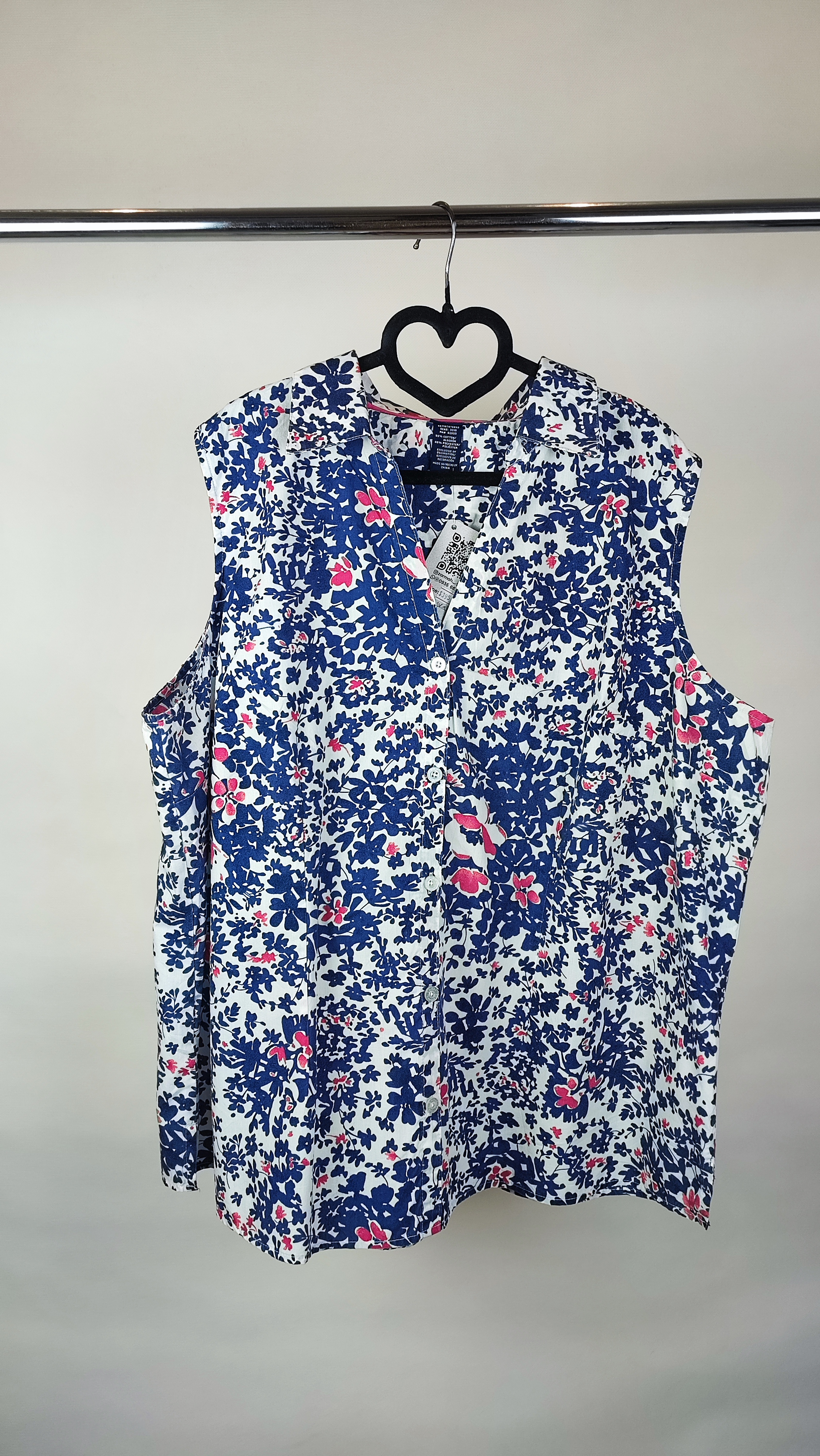 زن سایزبزرگ با تاپ بدون‌آستین آبی طرح‌دار و شلوار جین در پس‌زمینه ساده.»