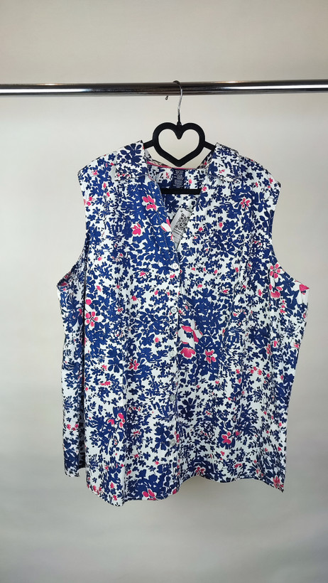 زن سایزبزرگ با تاپ بدونآستین آبی طرحدار و شلوار جین در پسزمینه ساده.»