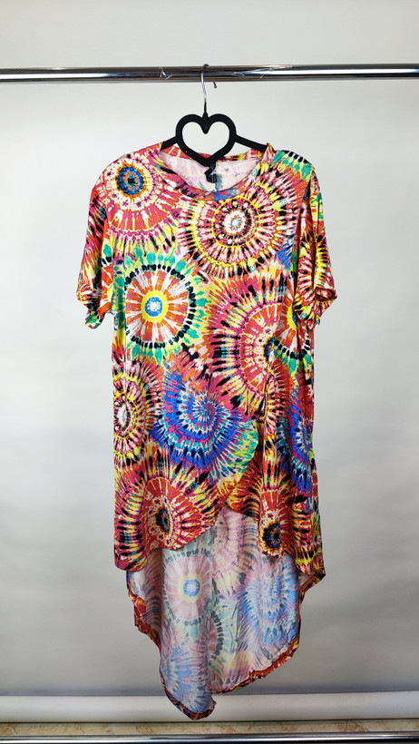 تونیک زنانه طرحدار چندرنگ با قد جلوی کوتاه و پشت بلند روی تن مدل، پسزمینه روشن.»