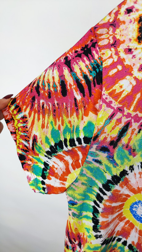 تونیک زنانه طرحدار چندرنگ با قد جلوی کوتاه و پشت بلند روی تن مدل، پسزمینه روشن.»