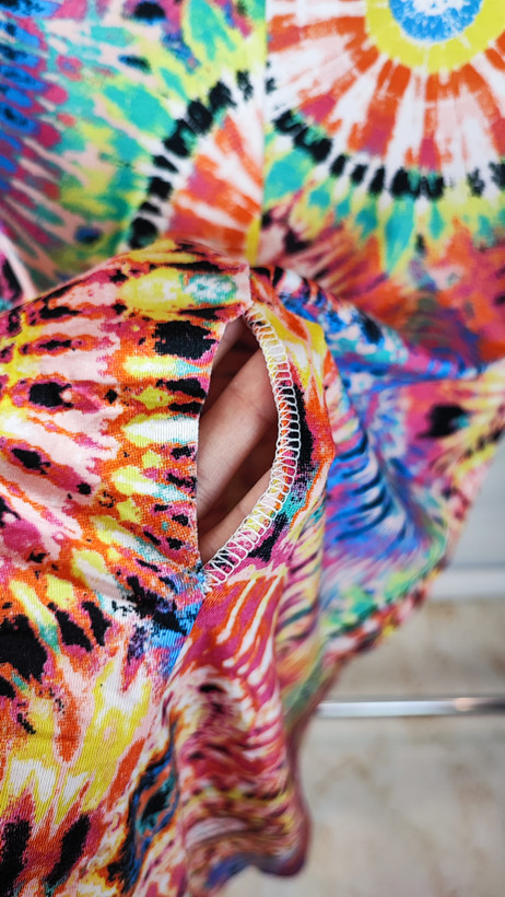 تونیک زنانه طرحدار چندرنگ با قد جلوی کوتاه و پشت بلند روی تن مدل، پسزمینه روشن.»