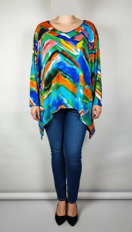 بلوز زنانه سایز بزرگ با طرح رنگارنگ آبی، نارنجی و سبز، آستینبلند، روی تن مانکن با شلوار جین تیره در پسزمینه روشن.»