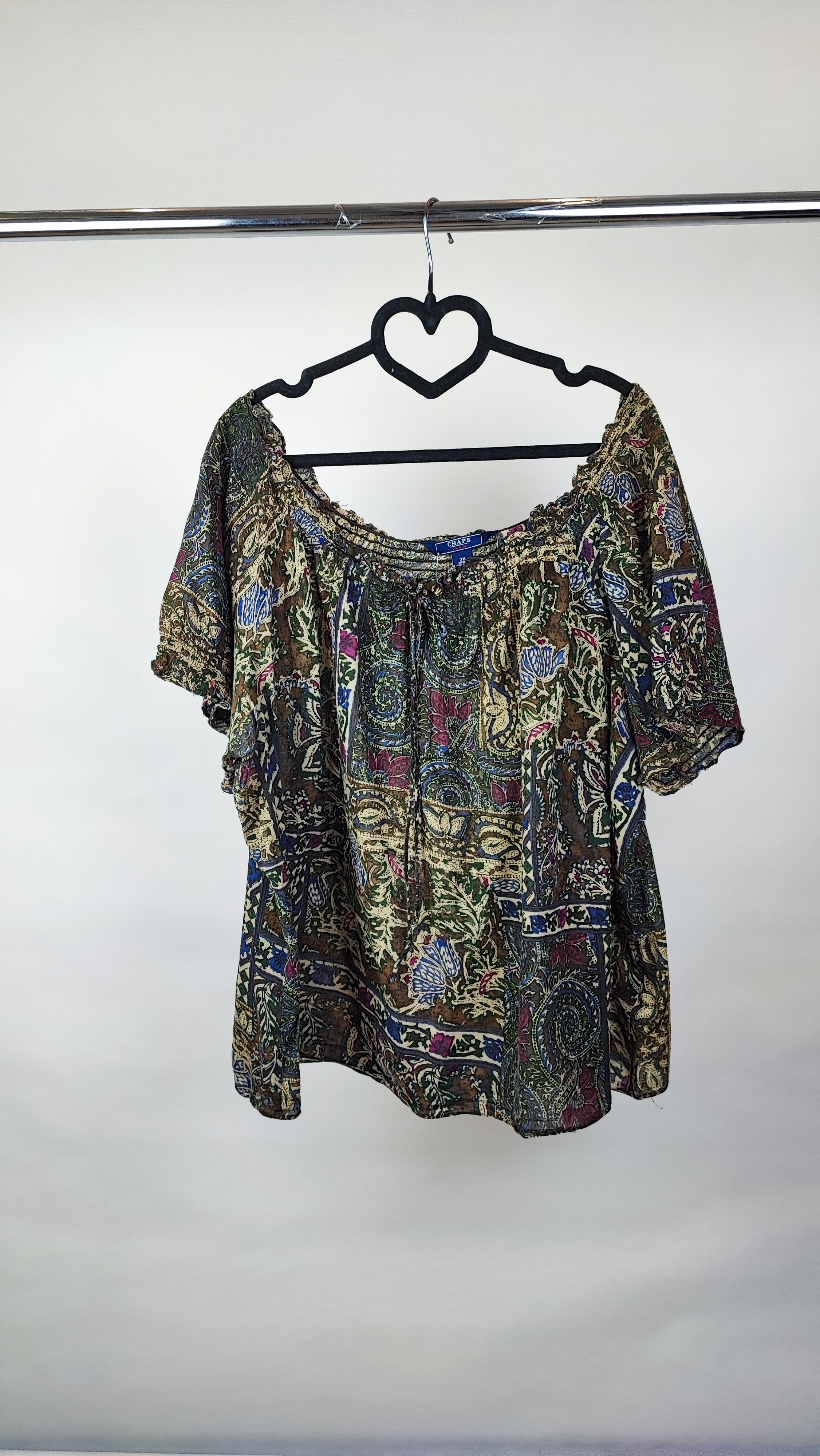 شومیز زنانه سایز بزرگ با طرح مشکی‌طلایی، آستین‌کوتاه، روی تن مانکن با شلوار مشکی در پس‌زمینه روشن.»