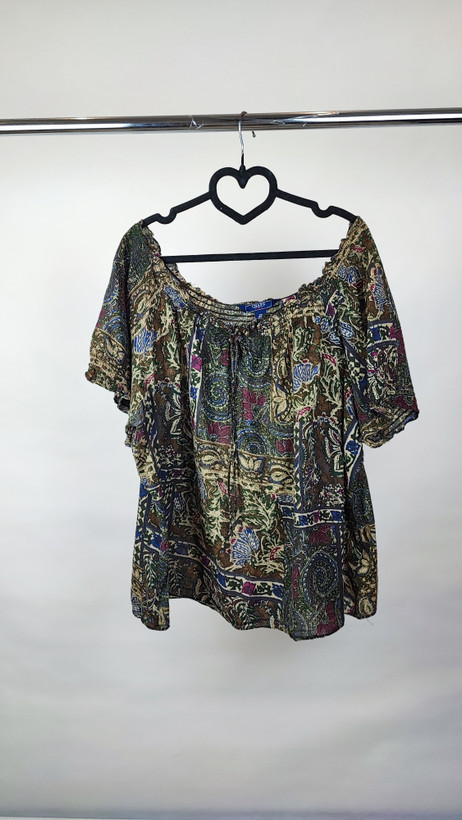 شومیز زنانه سایز بزرگ با طرح مشکیطلایی، آستینکوتاه، روی تن مانکن با شلوار مشکی در پسزمینه روشن.»