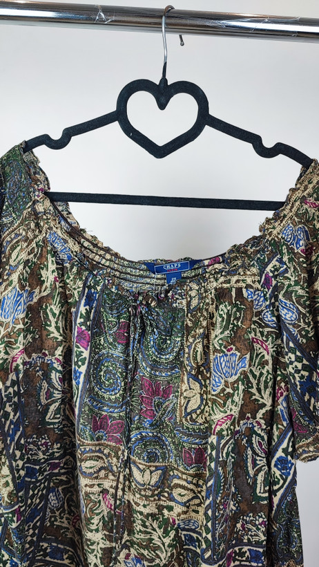 شومیز زنانه سایز بزرگ با طرح مشکیطلایی، آستینکوتاه، روی تن مانکن با شلوار مشکی در پسزمینه روشن.»