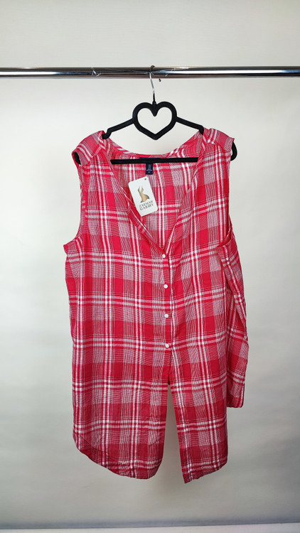 تاپ زنانه سایز بزرگ چهارخونه صورتی و قرمز، بدون آستین با گره جلو، روی تن مانکن با شلوار تیره در پسزمینه روشن.»