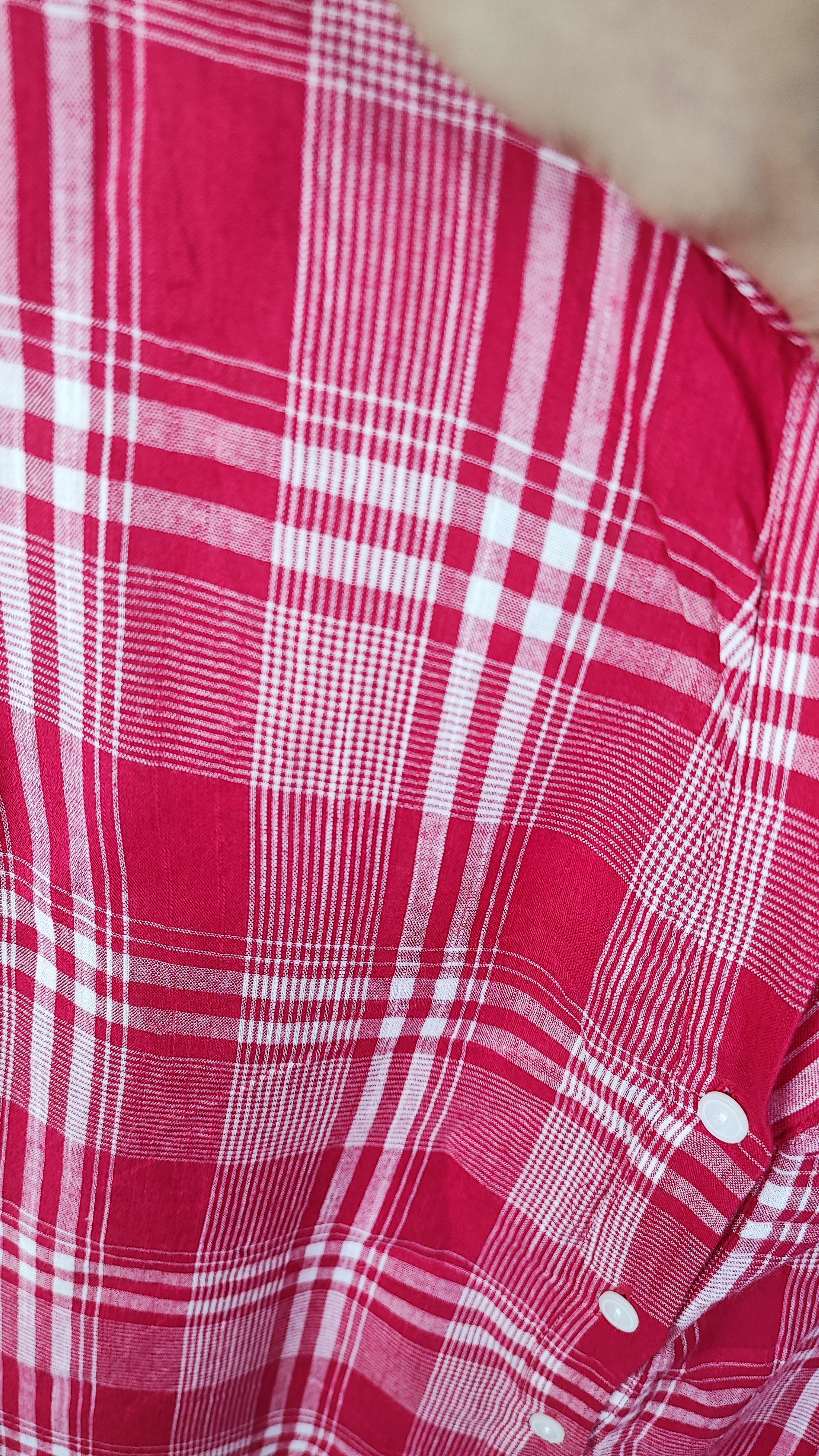 تاپ زنانه سایز بزرگ چهارخونه صورتی و قرمز، بدون آستین با گره جلو، روی تن مانکن با شلوار تیره در پس‌زمینه روشن.»