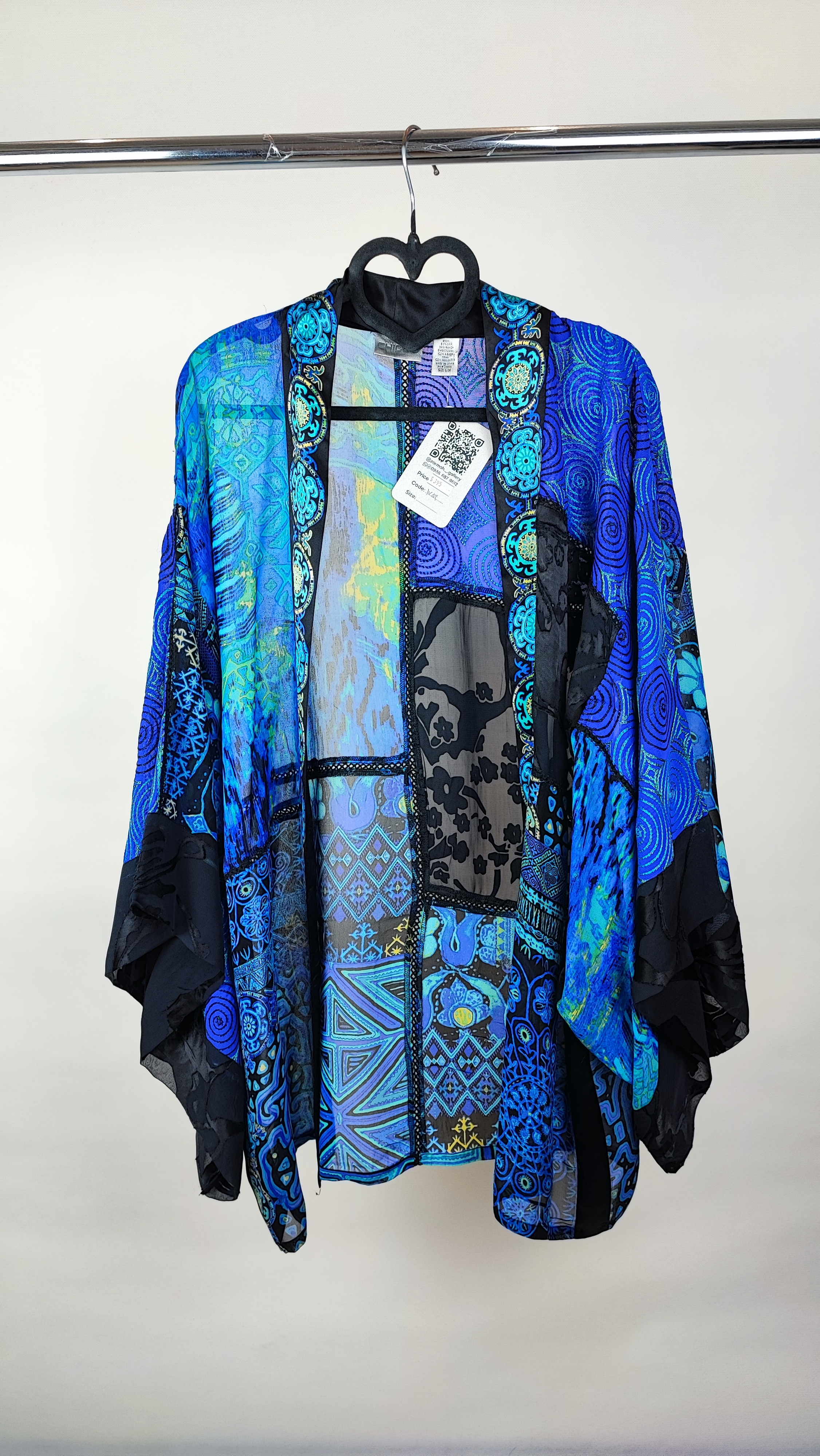 رویه شومیز زنانه فری‌سایز با ترکیب رنگ آبی‑سبز، آستین آزاد و فرم کِپ، روی تاپ مشکی، در پس‌زمینه روشن.»