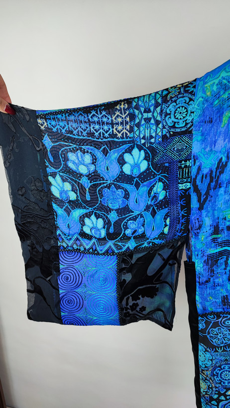 رویه شومیز زنانه فریسایز با ترکیب رنگ آبی‑سبز، آستین آزاد و فرم کِپ، روی تاپ مشکی، در پسزمینه روشن.»