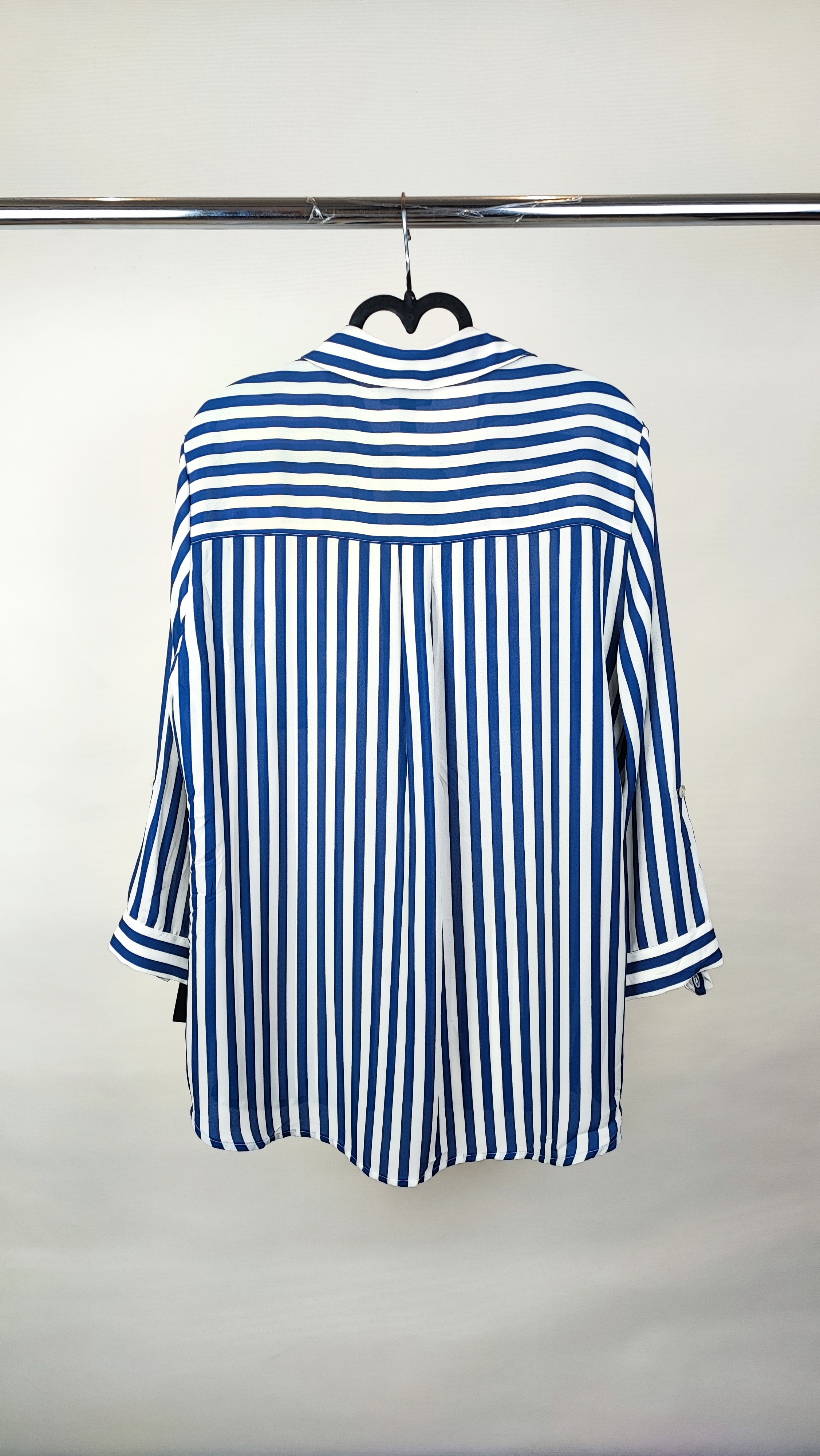 شومیز زنانه آبی راه‌راه سایز بزرگ با آستین بلند و مدل آزاد، روی تن مانکن با شلوار تیره، پس‌زمینه روشن.»