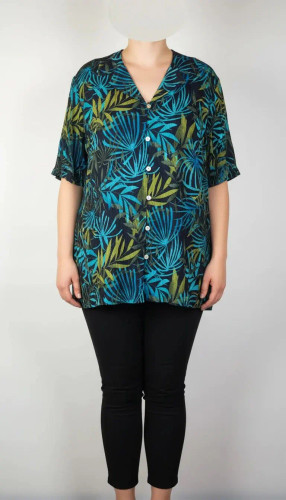 شومیز زنانه سایز بزرگ با زمینه سبزآبی و طرح گلهای زرد و نارنجی، آستین کوتاه و فرم آزاد روی تن مانکن، پسزمینه روشن.»