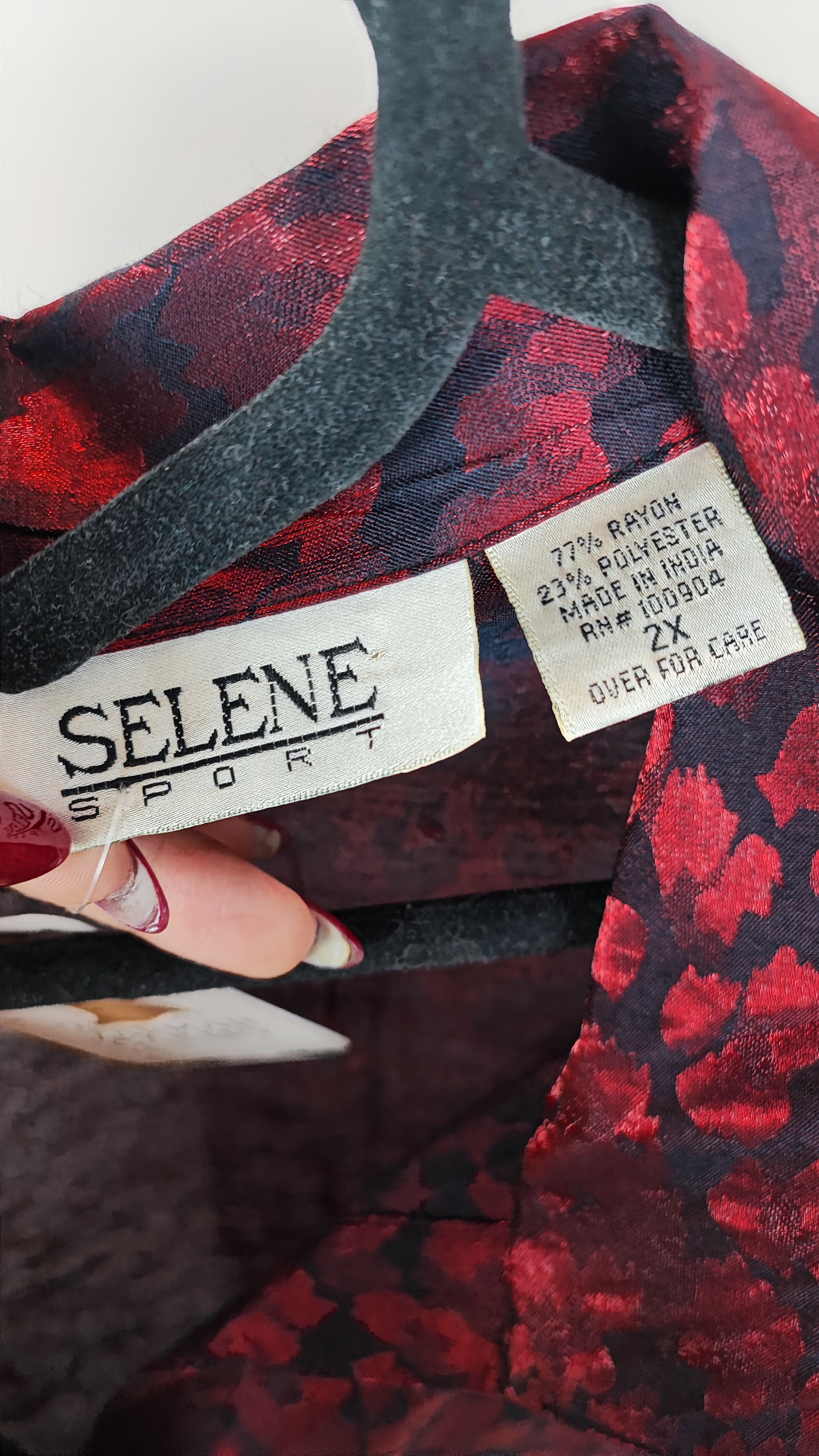 شومیز زنانه سایز بزرگ به رنگ زرشکی طرح‌دار با آستین سه‌ربع و فرم آزاد روی تن مانکن، پس‌زمینه روشن.»