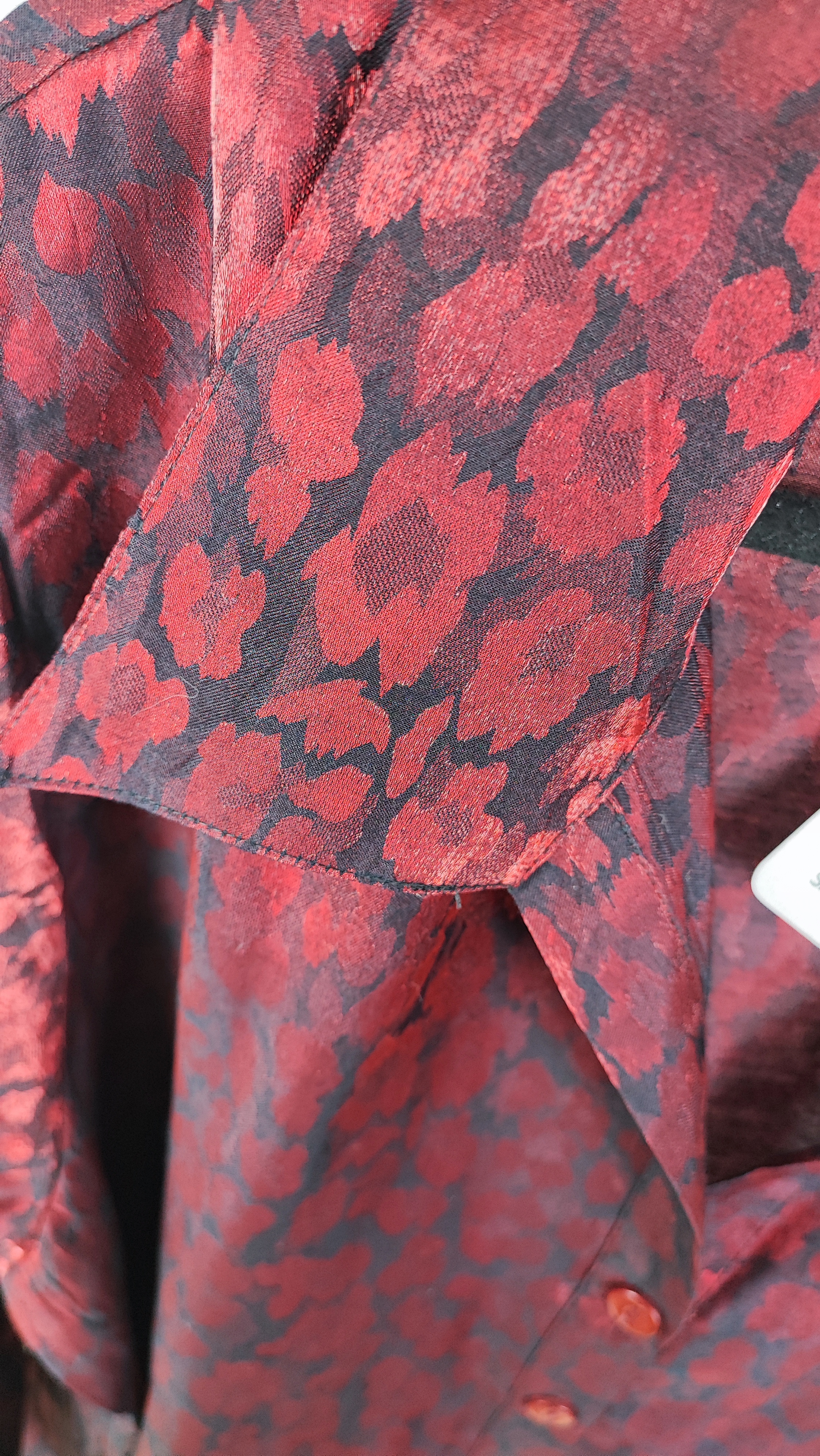 شومیز زنانه سایز بزرگ به رنگ زرشکی طرح‌دار با آستین سه‌ربع و فرم آزاد روی تن مانکن، پس‌زمینه روشن.»