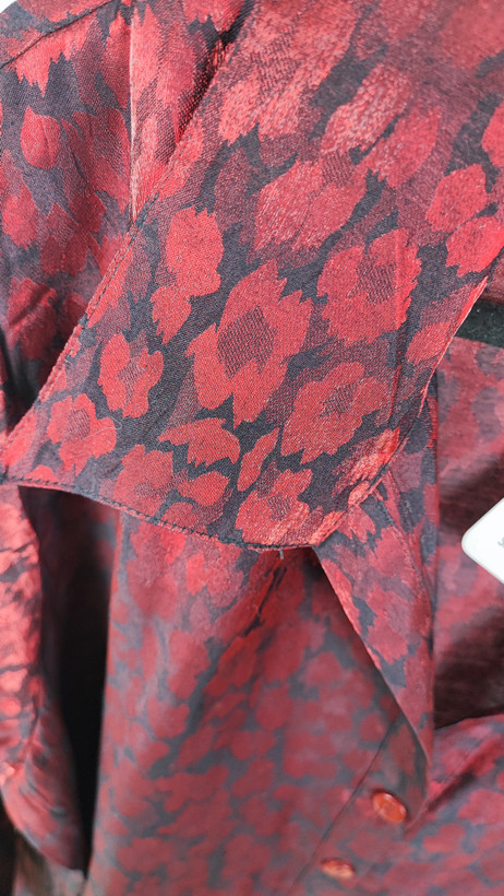 شومیز زنانه سایز بزرگ به رنگ زرشکی طرحدار با آستین سهربع و فرم آزاد روی تن مانکن، پسزمینه روشن.»