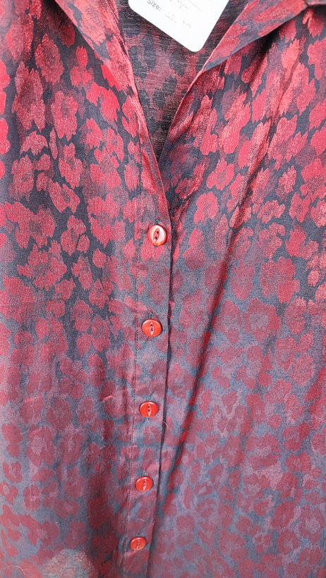 شومیز زنانه سایز بزرگ به رنگ زرشکی طرحدار با آستین سهربع و فرم آزاد روی تن مانکن، پسزمینه روشن.»