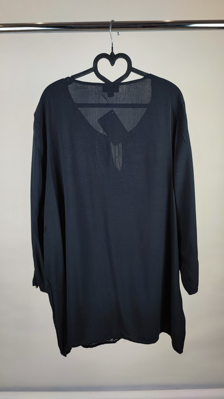 شومیز زنانه مشکی طرحدار با آستین بلند و فرم آزاد روی تن مانکن، پسزمینه روشن.»