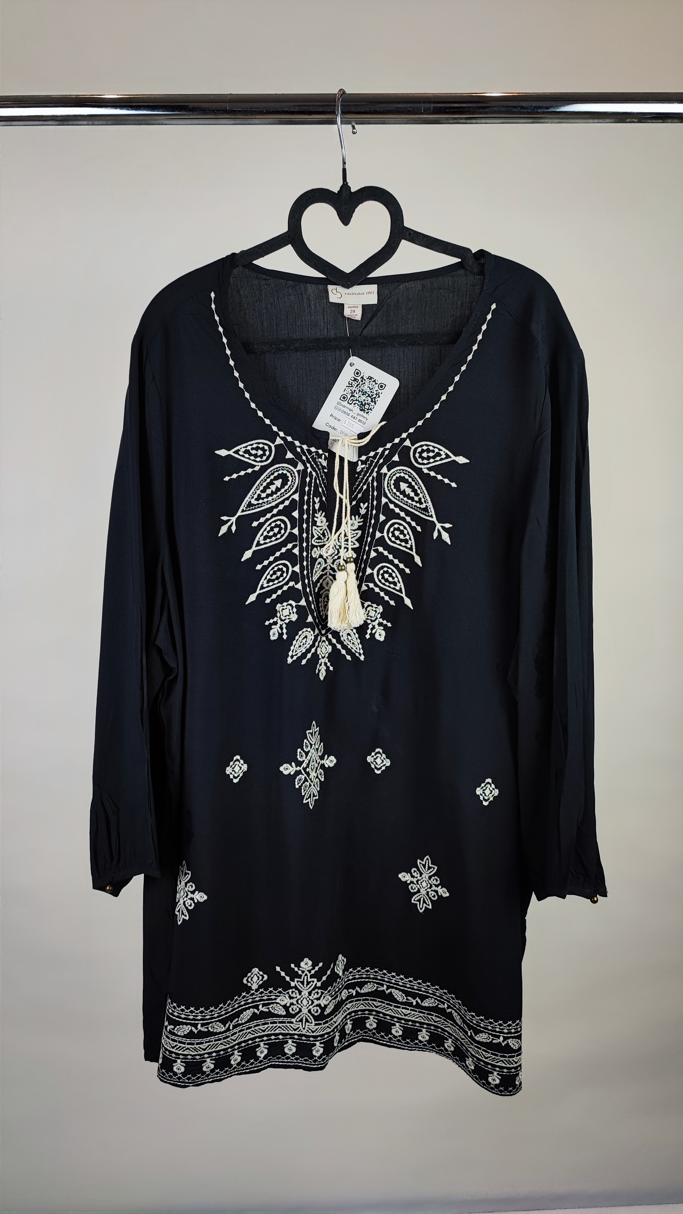 شومیز زنانه مشکی طرح‌دار با آستین بلند و فرم آزاد روی تن مانکن، پس‌زمینه روشن.»