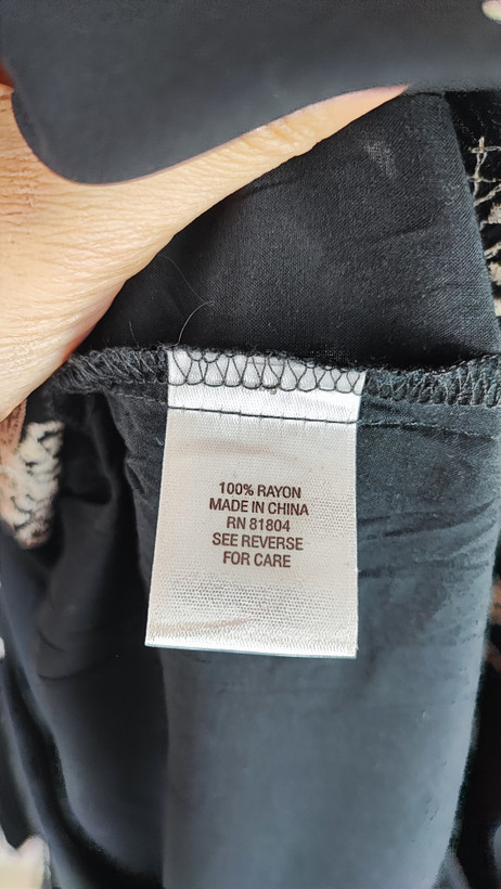 شومیز زنانه مشکی طرحدار با آستین بلند و فرم آزاد روی تن مانکن، پسزمینه روشن.»