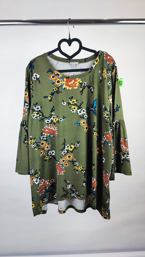 شومیز زنانه سایز بزرگ سبز طرحدار با آستین بلند و فرم آزاد روی تن مدل، پسزمینه روشن.