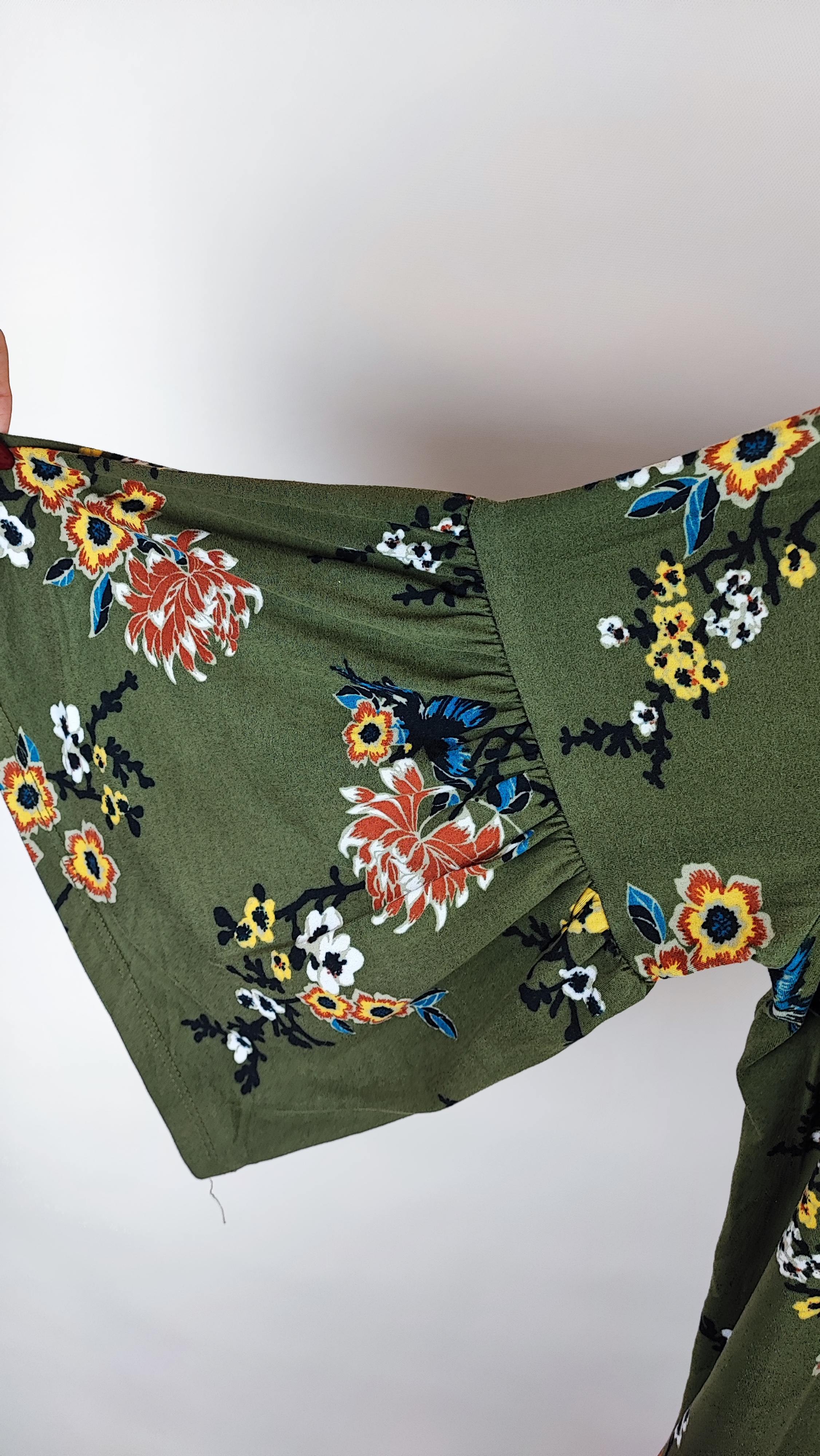 شومیز زنانه سایز بزرگ سبز طرح‌دار با آستین بلند و فرم آزاد روی تن مدل، پس‌زمینه روشن.