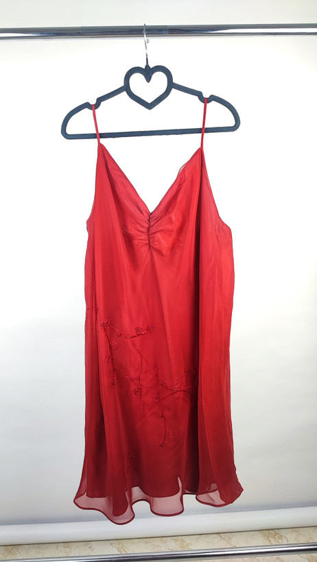 پیراهن زنانه استوک قرمز براق با بند نازک، مناسب سایز ۵۰–۵۲، قد ۱۰۰ سانتیمتر و فرم راحت روی تن مدل