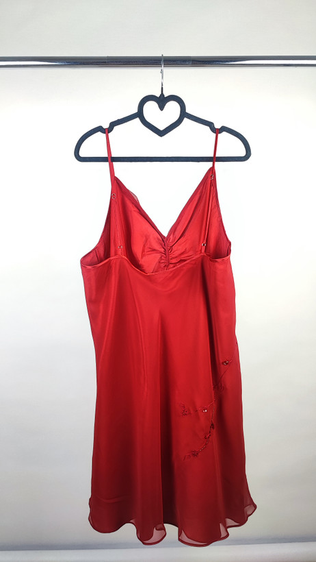 پیراهن زنانه استوک قرمز براق با بند نازک، مناسب سایز ۵۰–۵۲، قد ۱۰۰ سانتیمتر و فرم راحت روی تن مدل