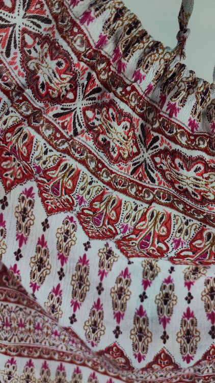 تاپ زنانه استوک طرحدار سایز ۴۲–۴۴ با عرض سینه ۵۲ و قد ۶۰، بدون آستین و فرم راحت روی تن مدل.