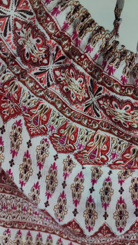 تاپ زنانه استوک طرحدار سایز ۴۲–۴۴ با عرض سینه ۵۲ و قد ۶۰، بدون آستین و فرم راحت روی تن مدل.