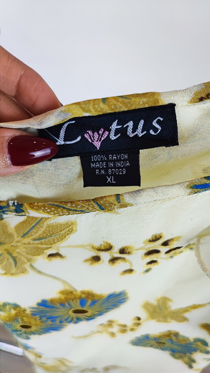 تاپ زنانه سایز بزرگ با پارچه سفید طرحدار ملایم سبز و آبی، بدون آستین، فرم آزاد و قد بلند روی تن مدل.